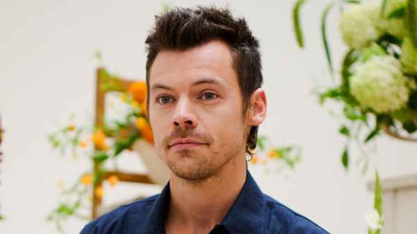 Harry Styles posing near flowers